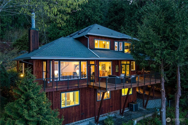 rear view of property with cooling unit and a wooden deck