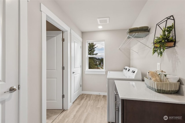 washroom with washer and dryer and light hardwood / wood-style floors