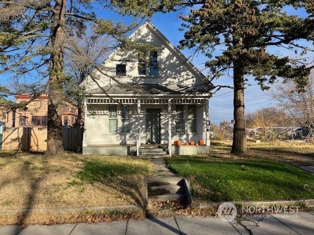 view of front of house with covered porch and a front yard