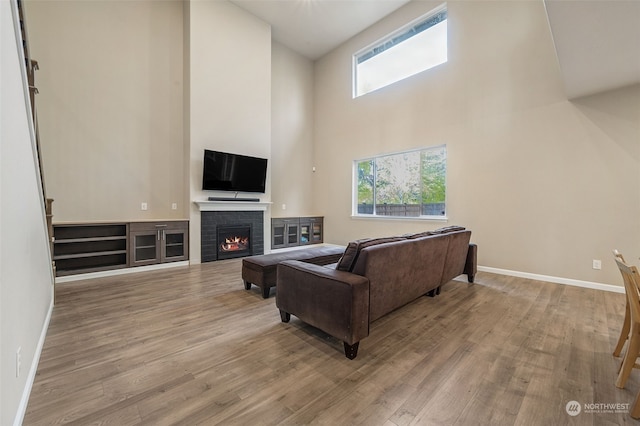 living room with a wealth of natural light, light hardwood / wood-style flooring, and high vaulted ceiling