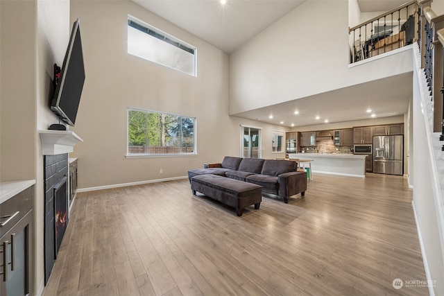 living room featuring a towering ceiling and light wood-type flooring