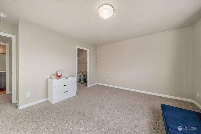 unfurnished bedroom with light carpet, a walk in closet, and a closet