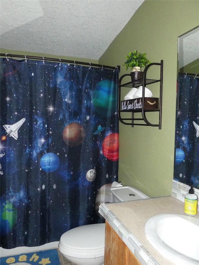 bathroom featuring vanity, toilet, and a textured ceiling