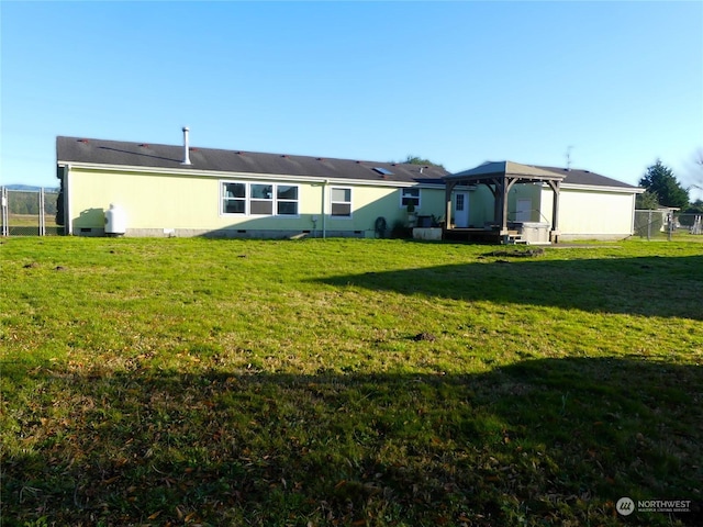 back of property featuring a gazebo and a yard