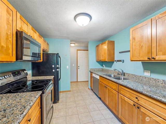 kitchen featuring light stone countertops, sink, stainless steel appliances, a textured ceiling, and light tile patterned flooring