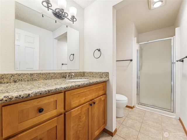 bathroom with tile patterned floors, vanity, a shower with shower door, and a textured ceiling