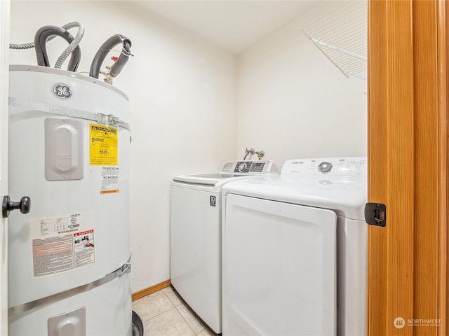 clothes washing area featuring strapped water heater, light tile patterned floors, and washing machine and dryer