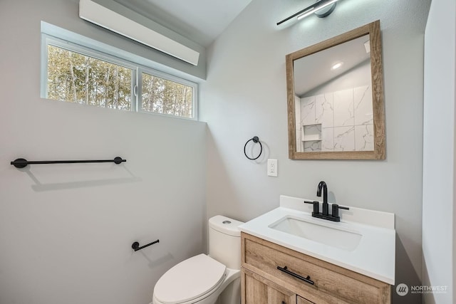 bathroom with vanity, lofted ceiling, and toilet