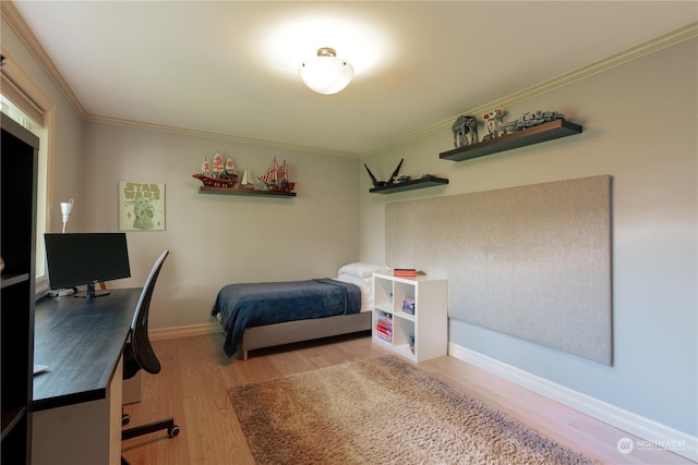 bedroom with crown molding, baseboards, and wood finished floors