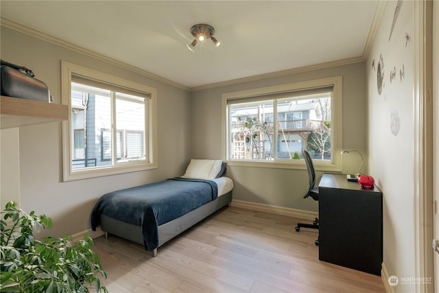 bedroom featuring baseboards, multiple windows, light wood-type flooring, and crown molding