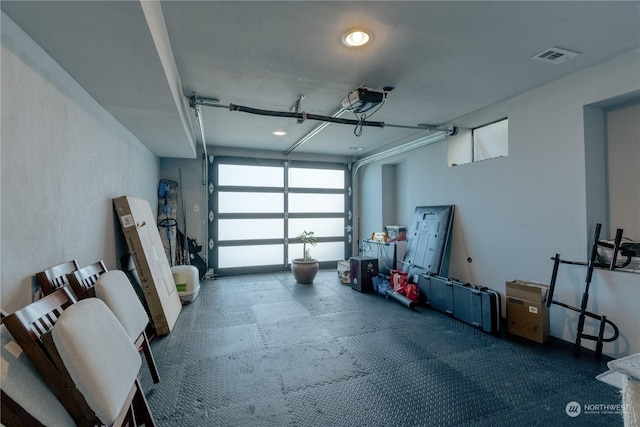 garage with a garage door opener and visible vents