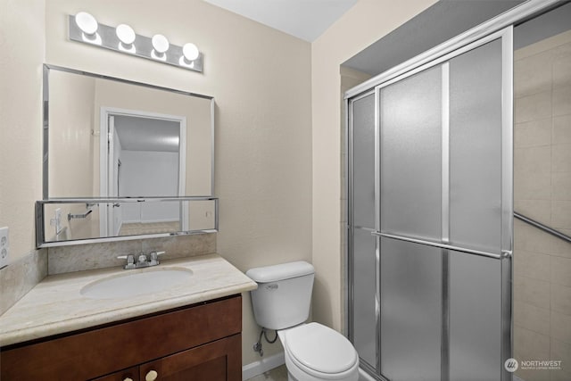 bathroom featuring vanity, toilet, and walk in shower