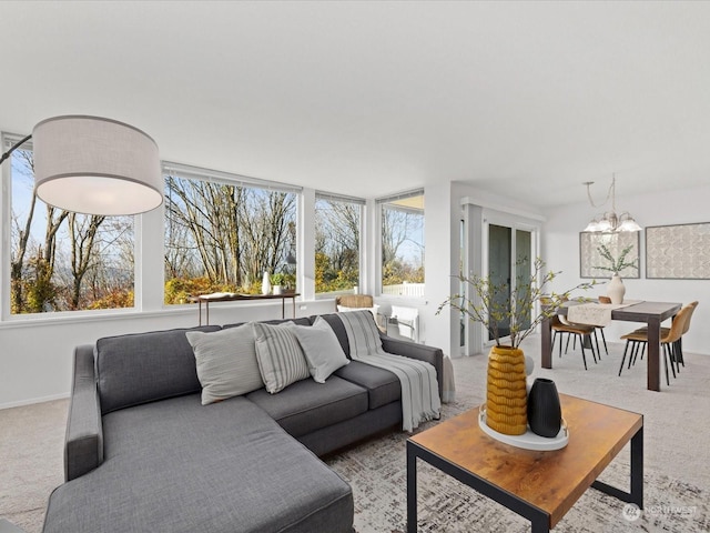 carpeted living room featuring a wealth of natural light and a chandelier