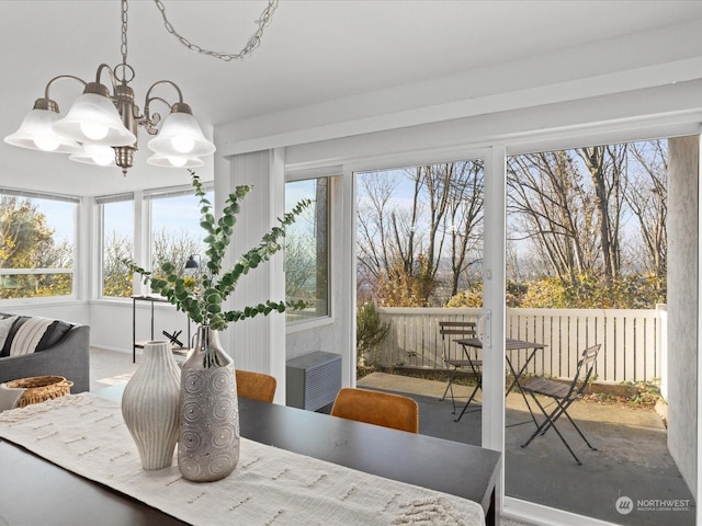 sunroom / solarium featuring an inviting chandelier