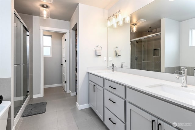 bathroom featuring vanity, tile patterned flooring, and a shower with door