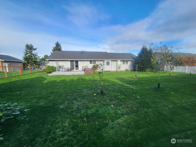 rear view of house featuring a yard and a patio