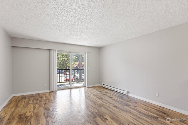 spare room with wood-type flooring, a textured ceiling, and a baseboard radiator