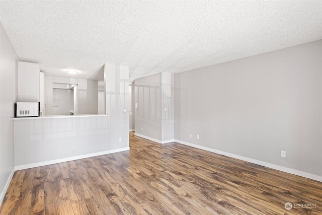 unfurnished living room with a textured ceiling and hardwood / wood-style flooring