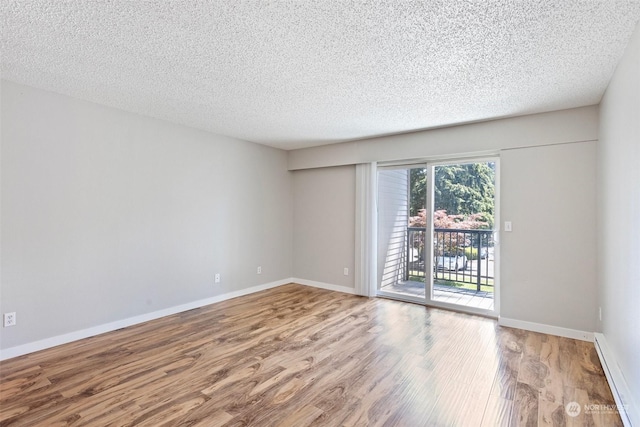 unfurnished room with hardwood / wood-style floors and a textured ceiling