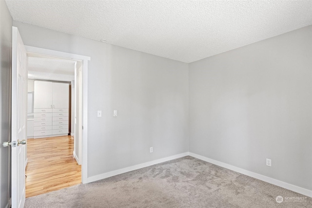 unfurnished room featuring a textured ceiling and carpet floors