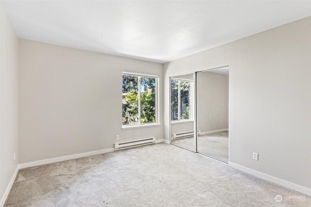 carpeted empty room with baseboard heating