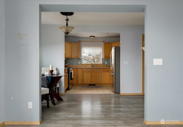 233 Calhoun Loop, Coupeville, WA 98239 - kitchen featuring stainless steel appliances, light wood finished floors, baseboards, a sink, and tasteful backsplash