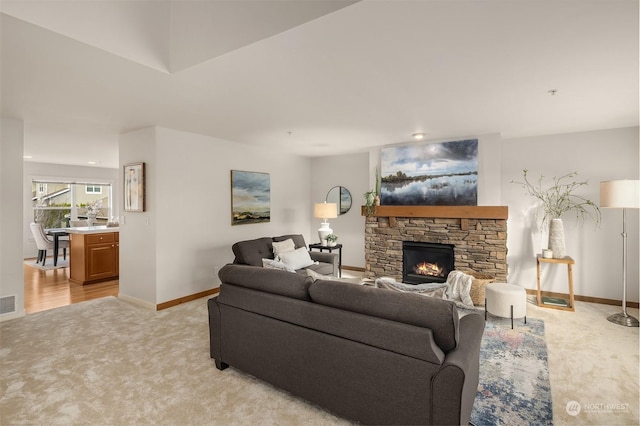 carpeted living room with a stone fireplace