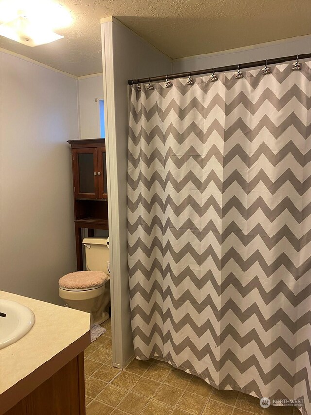 bathroom featuring vanity, tile patterned floors, toilet, a textured ceiling, and walk in shower