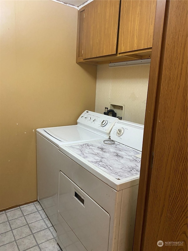 washroom with washing machine and dryer and cabinets