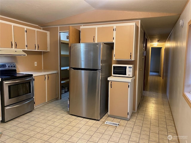 kitchen featuring cream cabinetry, lofted ceiling, and appliances with stainless steel finishes