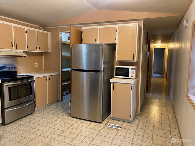 kitchen featuring cream cabinetry, lofted ceiling, and appliances with stainless steel finishes