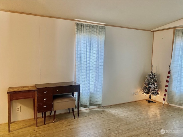 misc room with light hardwood / wood-style floors, lofted ceiling, and ornamental molding