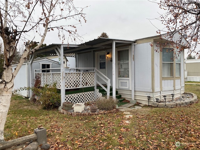 view of front facade with a shed, a front lawn, and a porch