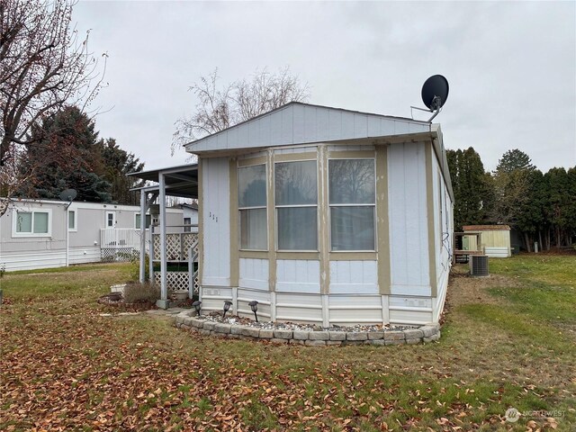 view of home's exterior with a yard and cooling unit