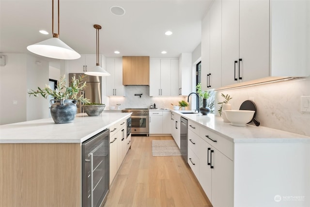 kitchen with wine cooler, white cabinets, hanging light fixtures, and appliances with stainless steel finishes