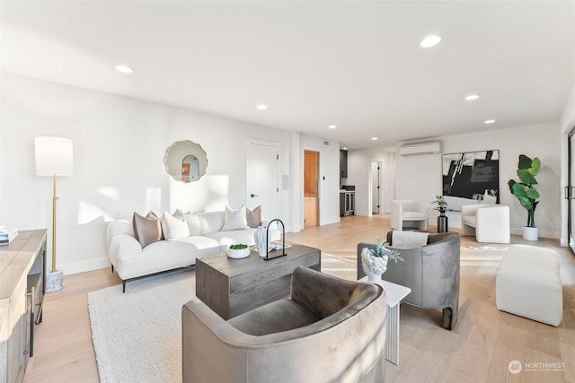 living room featuring a wall unit AC and light hardwood / wood-style floors