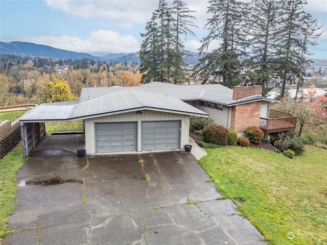 single story home with a front yard, a carport, a garage, and a deck with mountain view