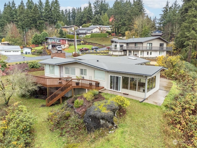 back of property featuring a lawn and a deck