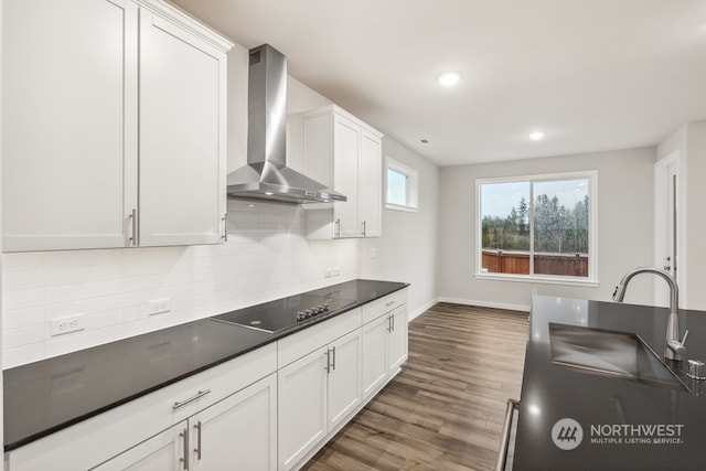 kitchen with sink, white cabinetry, black electric cooktop, dark hardwood / wood-style floors, and wall chimney range hood