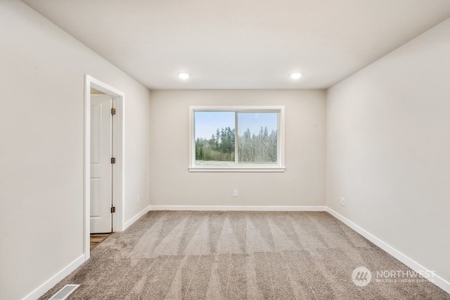 spare room featuring light carpet