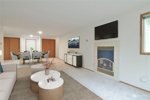 carpeted living room featuring a tiled fireplace