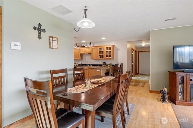 dining space with sink and light hardwood / wood-style floors