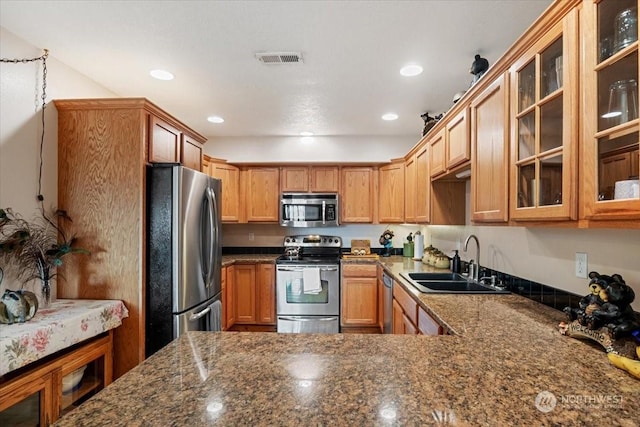 kitchen featuring dark stone countertops, sink, and stainless steel appliances