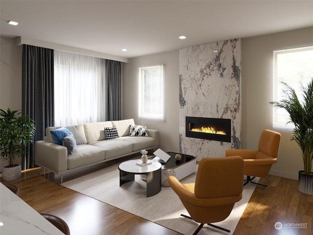 living room featuring a high end fireplace, light hardwood / wood-style floors, and a wealth of natural light