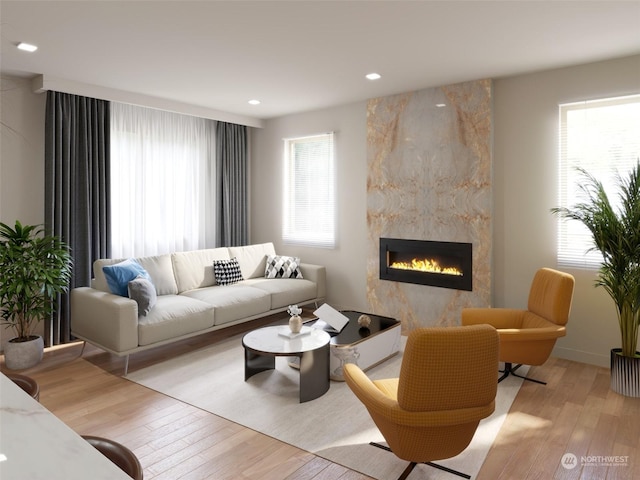 living room featuring a wealth of natural light, a fireplace, and light hardwood / wood-style floors