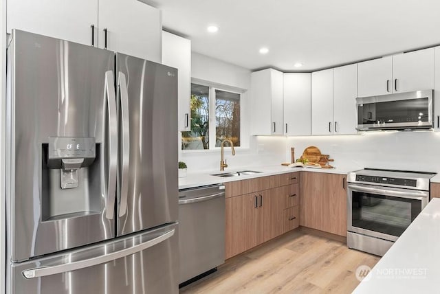 kitchen featuring light hardwood / wood-style floors, sink, white cabinetry, and stainless steel appliances