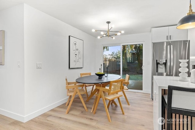 dining area featuring light hardwood / wood-style floors and an inviting chandelier