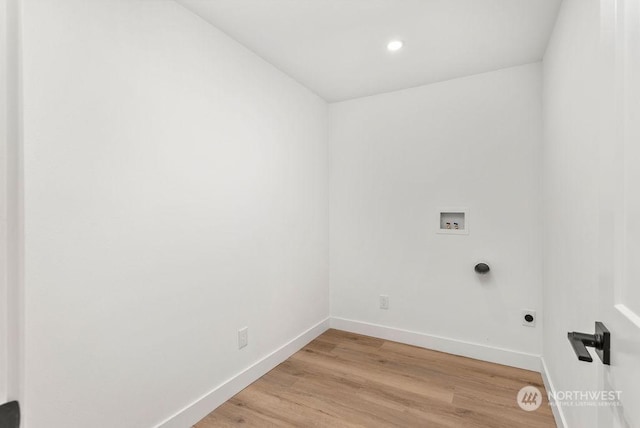 clothes washing area featuring electric dryer hookup, light hardwood / wood-style flooring, and washer hookup