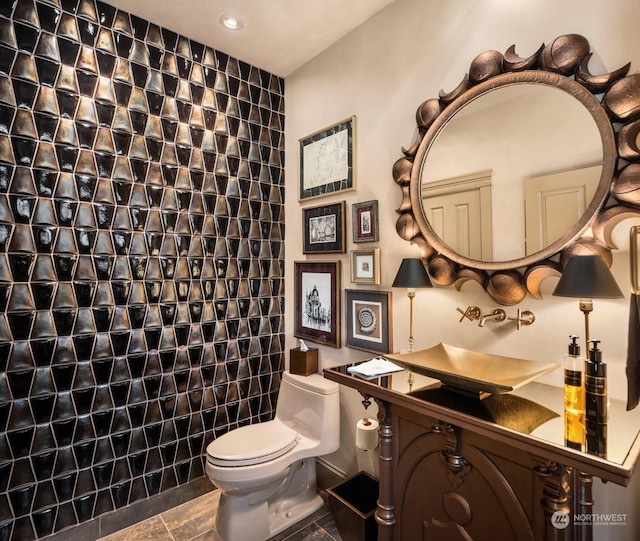 bathroom with toilet and tile walls