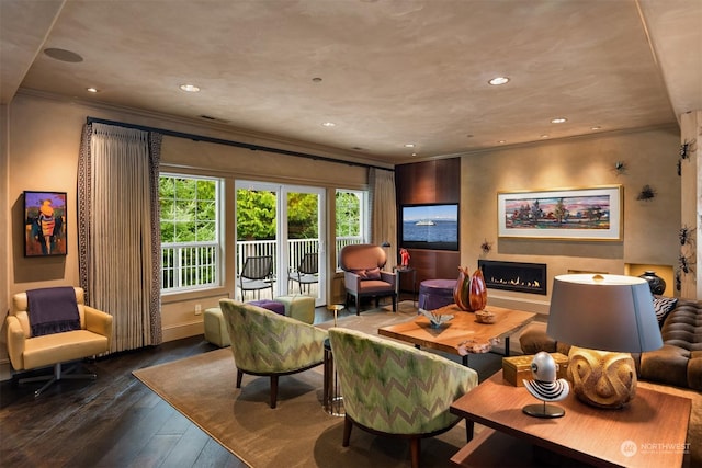 interior space with a lit fireplace, ornamental molding, hardwood / wood-style flooring, and recessed lighting